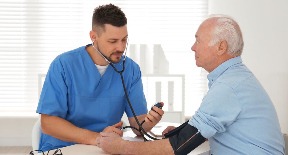 Doctor measuring blood pressure of senior patient in office