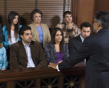 Rear view of a advocate communicating with the jurors in the court house