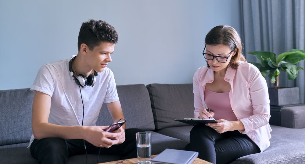 Teenage boy at meeting with female professional doctor psychologist